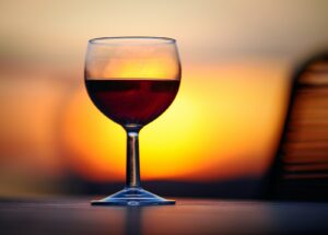 clear wine glass with red wine on brown wooden table