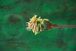 a person holding a fork with a bunch of food on it